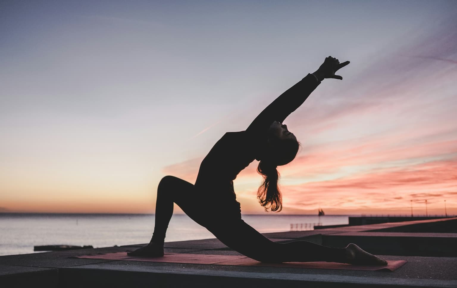 A person stretching on a mat in a bright room