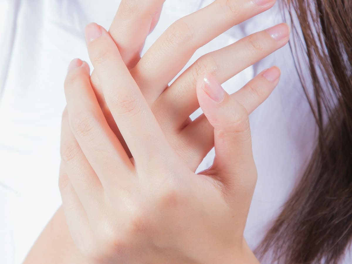 Person gently touching the face during neuromuscular recovery awareness exercises
